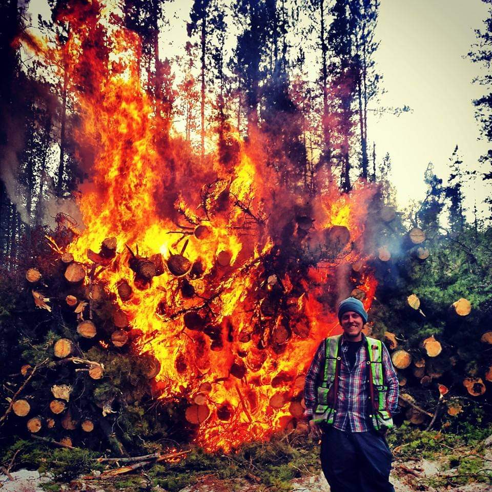 Nathan O'Reilley standing in front of a burn pile.