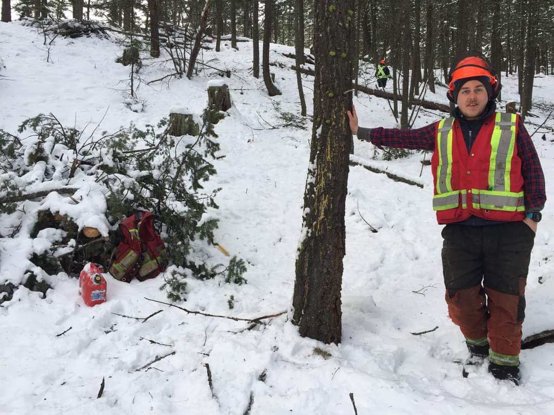 Nathan O'Reilley in safety gear standing next to tree